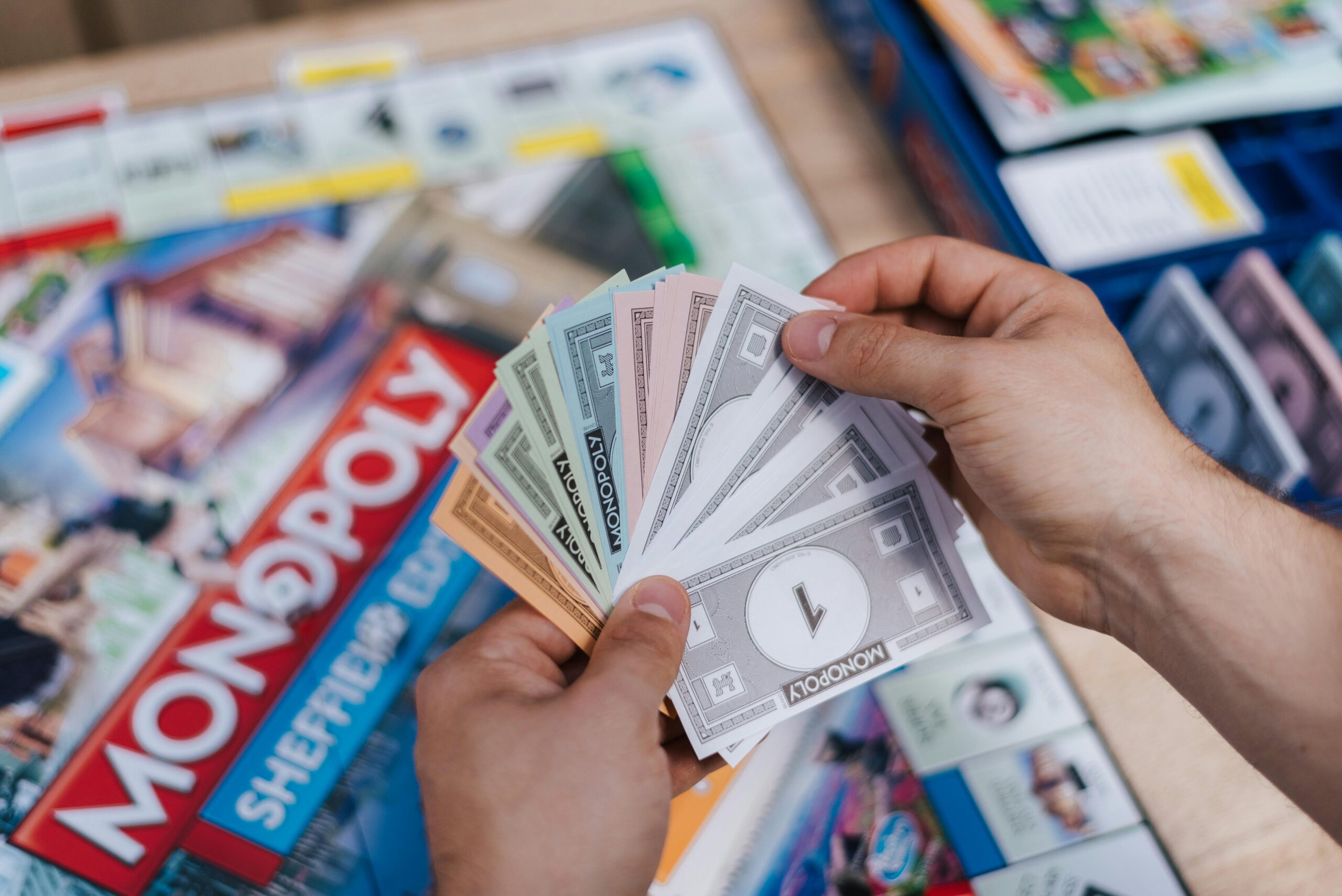 Player holding Monopoly money during a Monopoly Singapore Edition board game session.